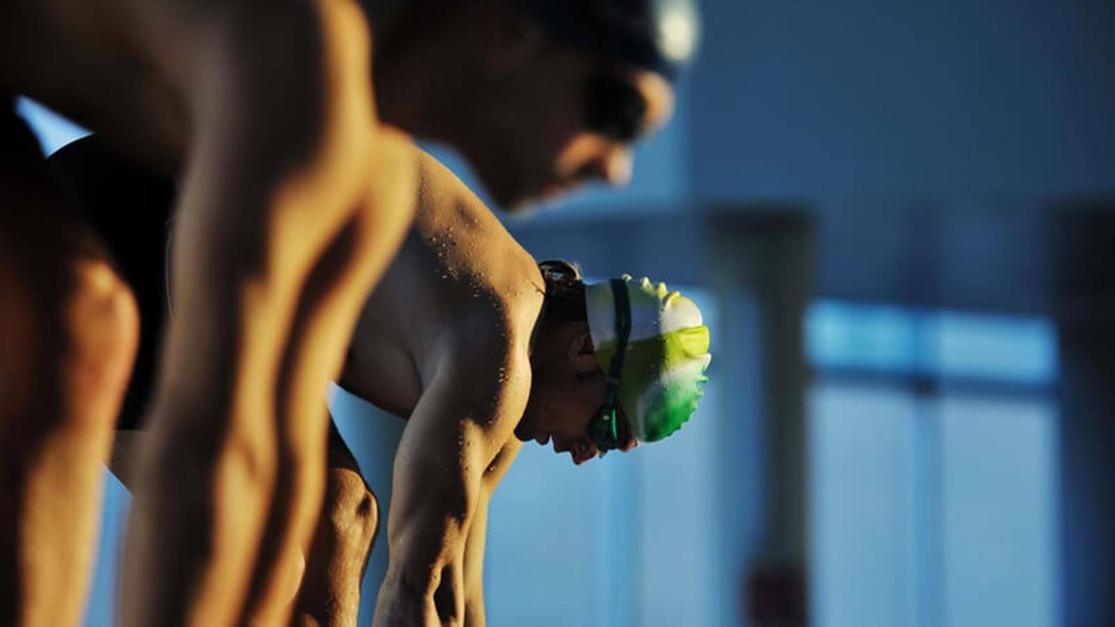 Swimmers preparing to launch into a pool 